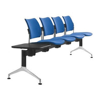 Banqueta de espera Dream tapizada completa, vista de tres cuartos, azul, con cuatro asientos y mesa lateral negra | VICCA
