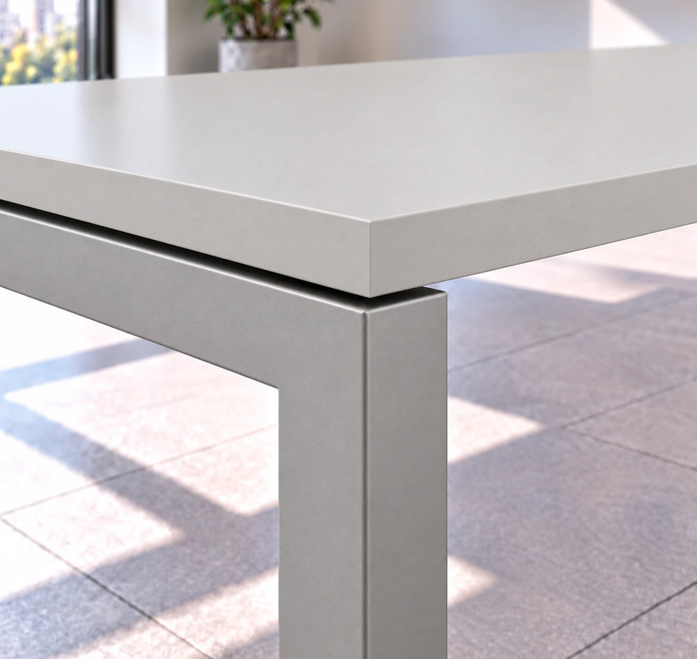 Detalle de la esquina de la mesa de reuniones VICCA: cubierta Niebla y separación sobre la estructura metálica color aluminio tipo bench.