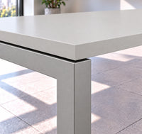 Detalle de la esquina de la mesa de reuniones VICCA: cubierta Niebla y separación sobre la estructura metálica color aluminio tipo bench.