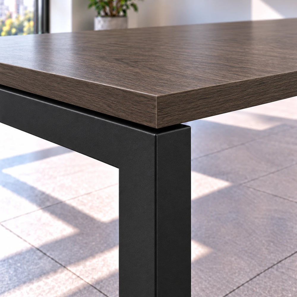 Detalle de la esquina de la mesa de reuniones para 14 personas: cubierta Brown Oak de 25 mm con canto de PVC sobre estructura metálica Negro MT tipo bench