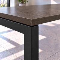 Detalle de la esquina de la mesa de reuniones para 14 personas: cubierta Brown Oak de 25 mm con canto de PVC sobre estructura metálica Negro MT tipo bench