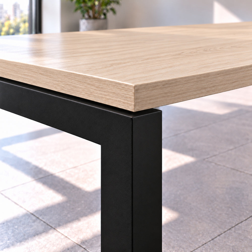 Detalle de estructura metálica negra tipo bench con perfil cuadrado de 50 × 50 mm y cubierta de 25 mm con canto de PVC, mostrando la ligera separación entre cubierta y estructura