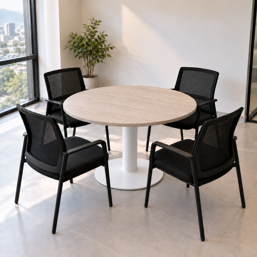 Mesa redonda de oficina para 4 personas con cubierta de madera clara y pedestal de plato circular blanco, tubo ancho y plato con suave descenso hacia el borde; sillas no incluidas